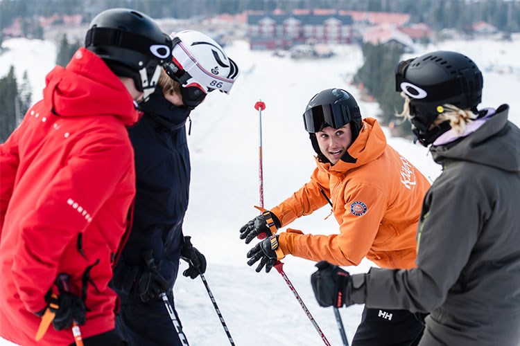 Skidläraren Mattias instruerar en grupp skidåkare.