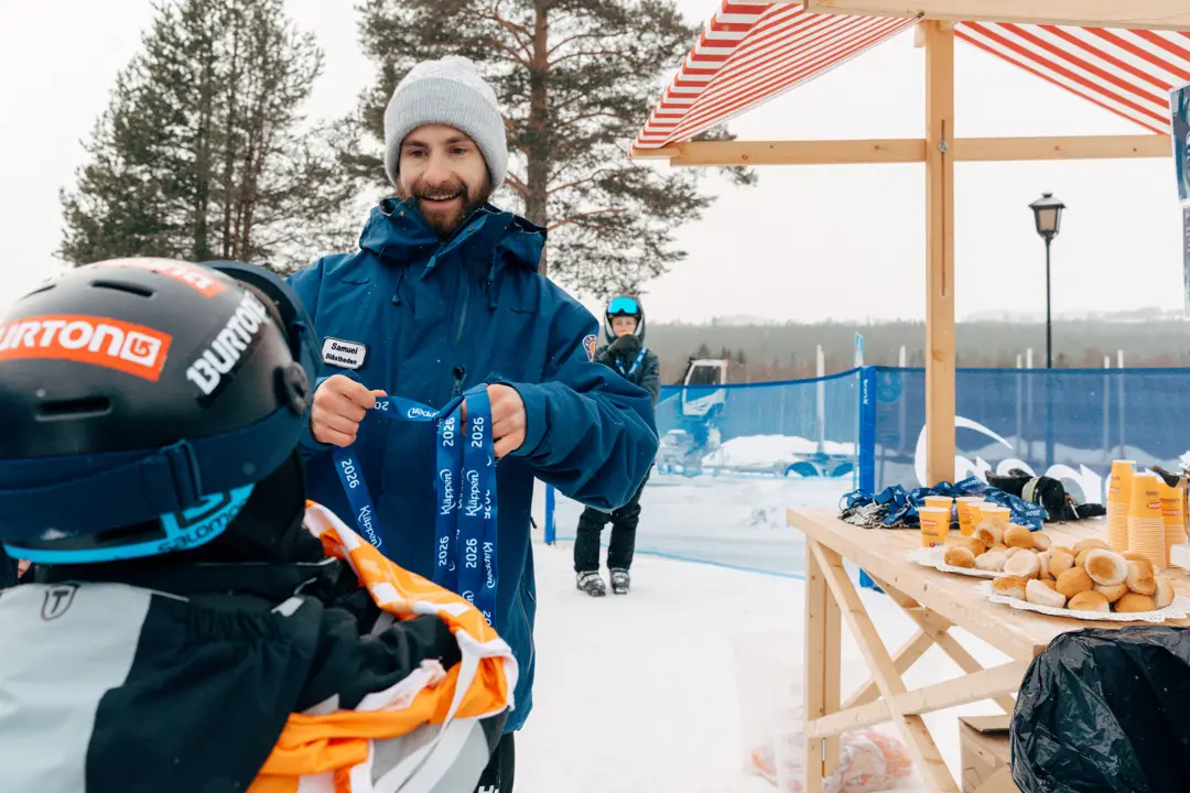 Personal på Kläppen hänger en medalj runt ett barns hals