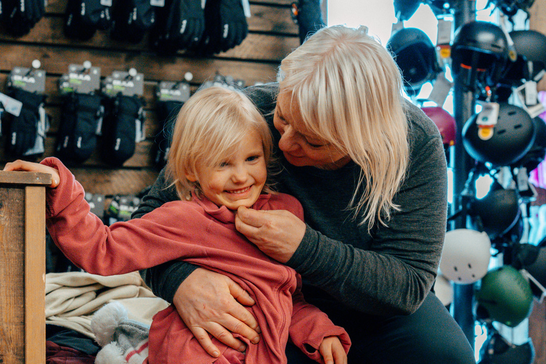 En mamma håller om sin dotter inne på skidhyran