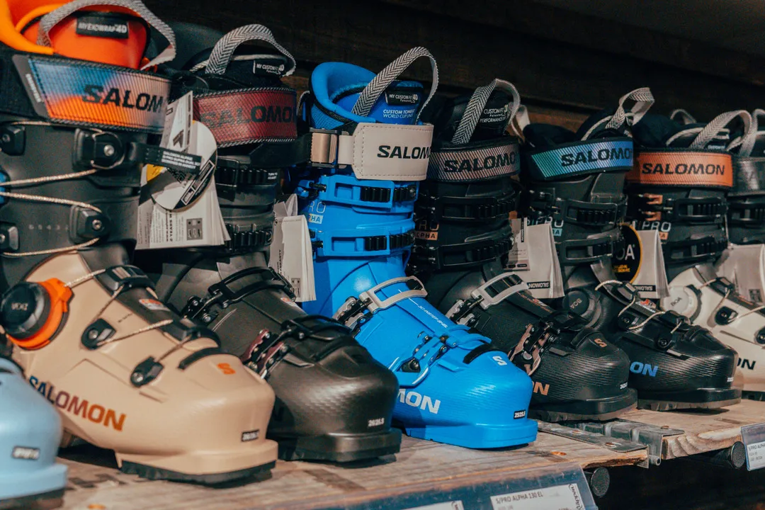 Uppradade alpinpjäxor på en hylla inne i butiken.