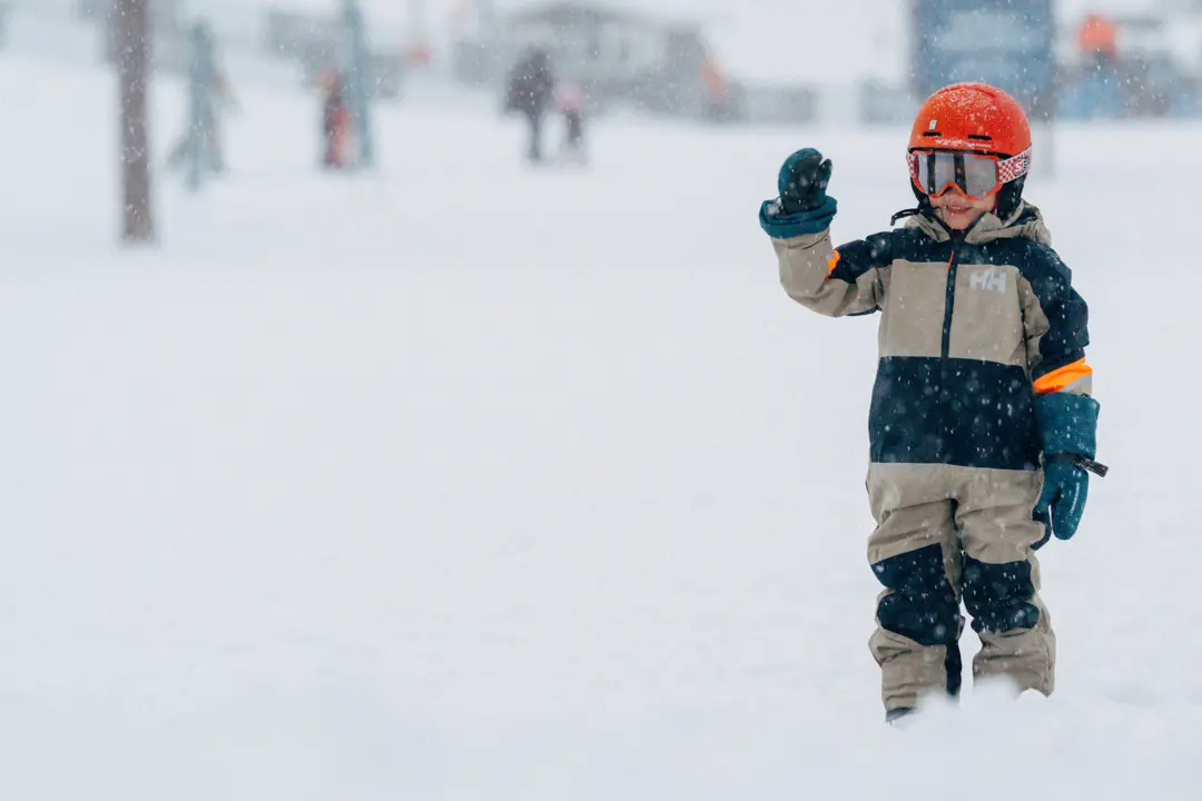 En flicka vinkar mot kameran