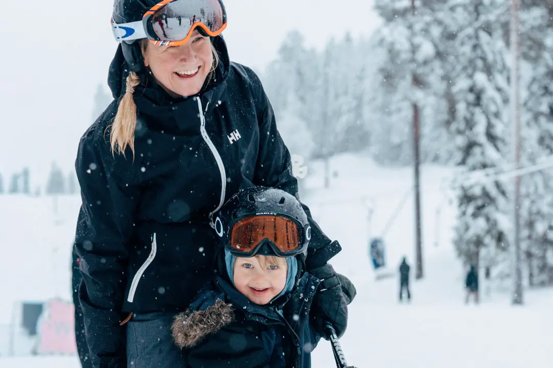 Två barn som åker på rullbandet i barnområdet