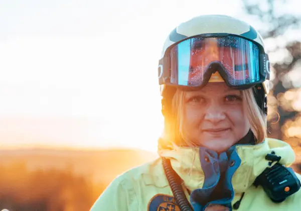 En kvinna från skidpatrullen står och ler mot kameran