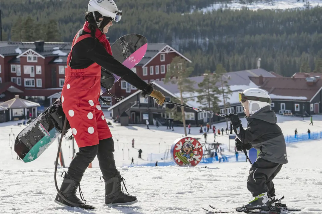 Trolla helps a child to ski