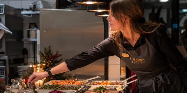 a waitress arranges the Christmas food on the Christmas buffet