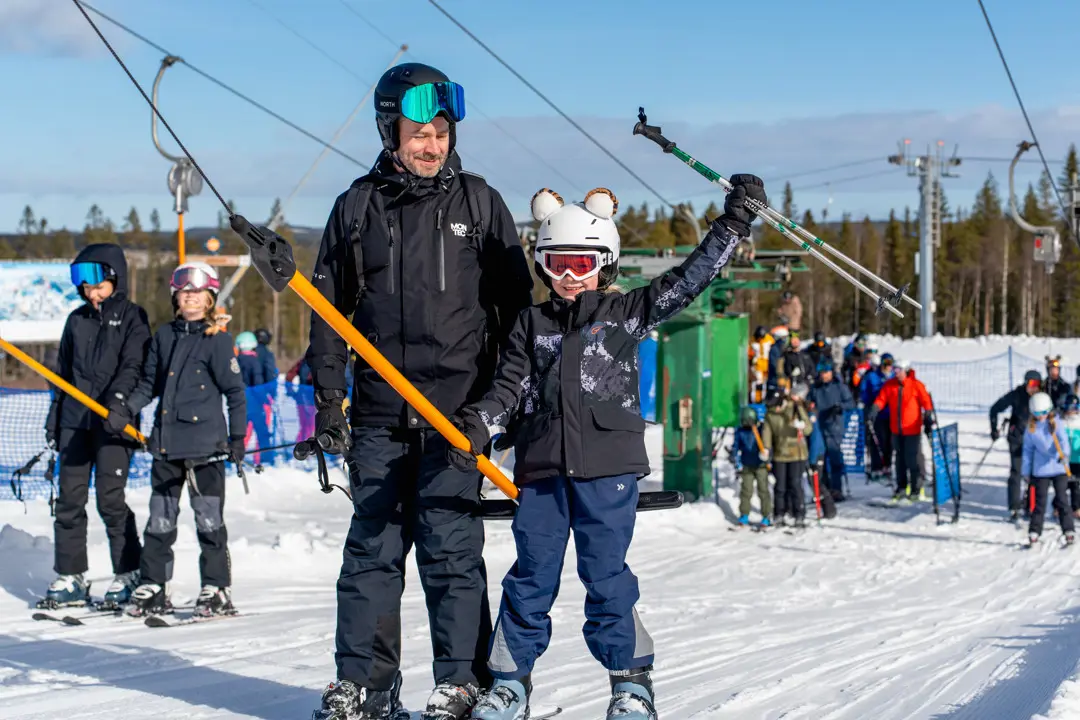 A father and daughter are taking the anchor lift at Kläppen.