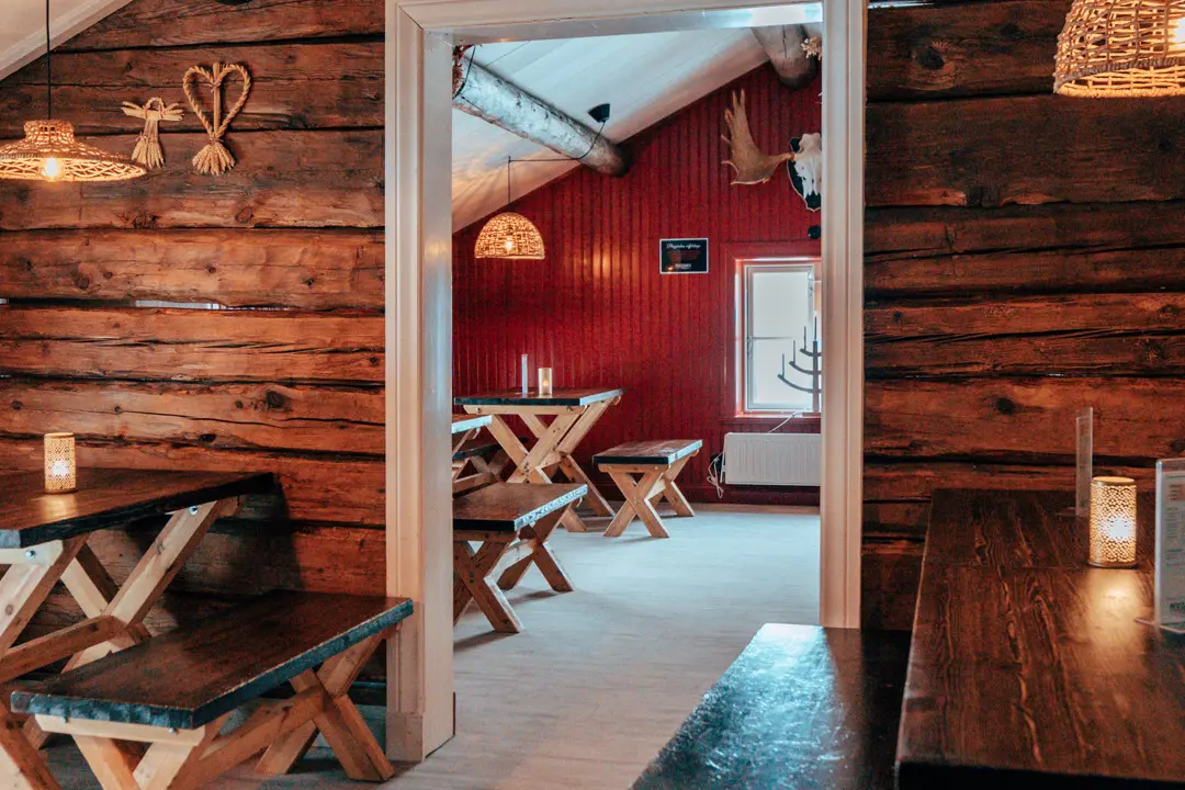En bild inne från våffelstugan med bord och bänkar